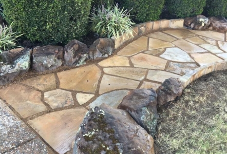 Moss Boulders lining an Oklahoma Flagstone walkways done by FGO Landscaping.