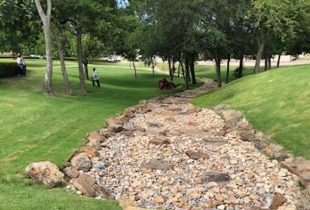 Rainbow River Rock and Moss Boulders creating a functional draining river bed next to City Hall.