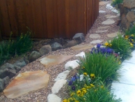 Walkway using moss boulders as eding, cinnamon gravel, and cherry blend flagstone.