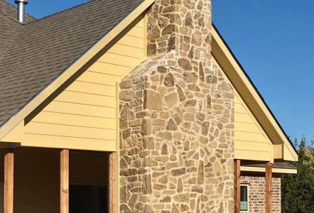 Oklahoma Tumbled Puzzle Rock (brown) on a chimney for Watermark Design Build Remodel.